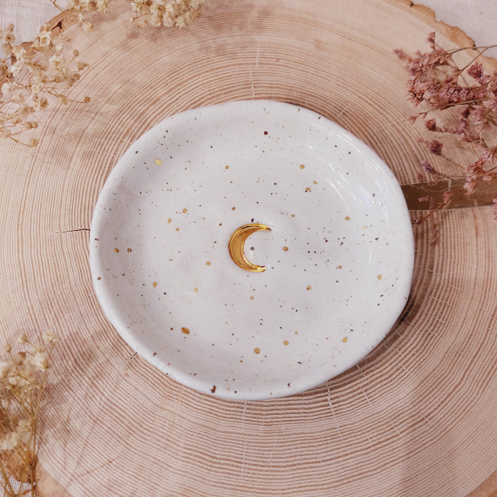 Na zdjęciu widać talerzyk, spodek ze złoceniem w kształcie księżyca.