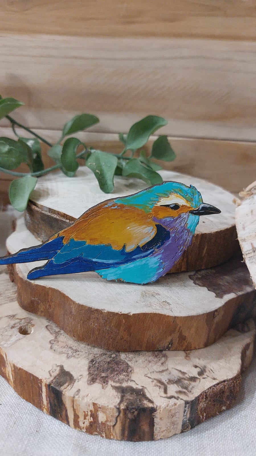 Na zdjęciu widać drewnianą broszkę przedstawiającą kraskę liliową.