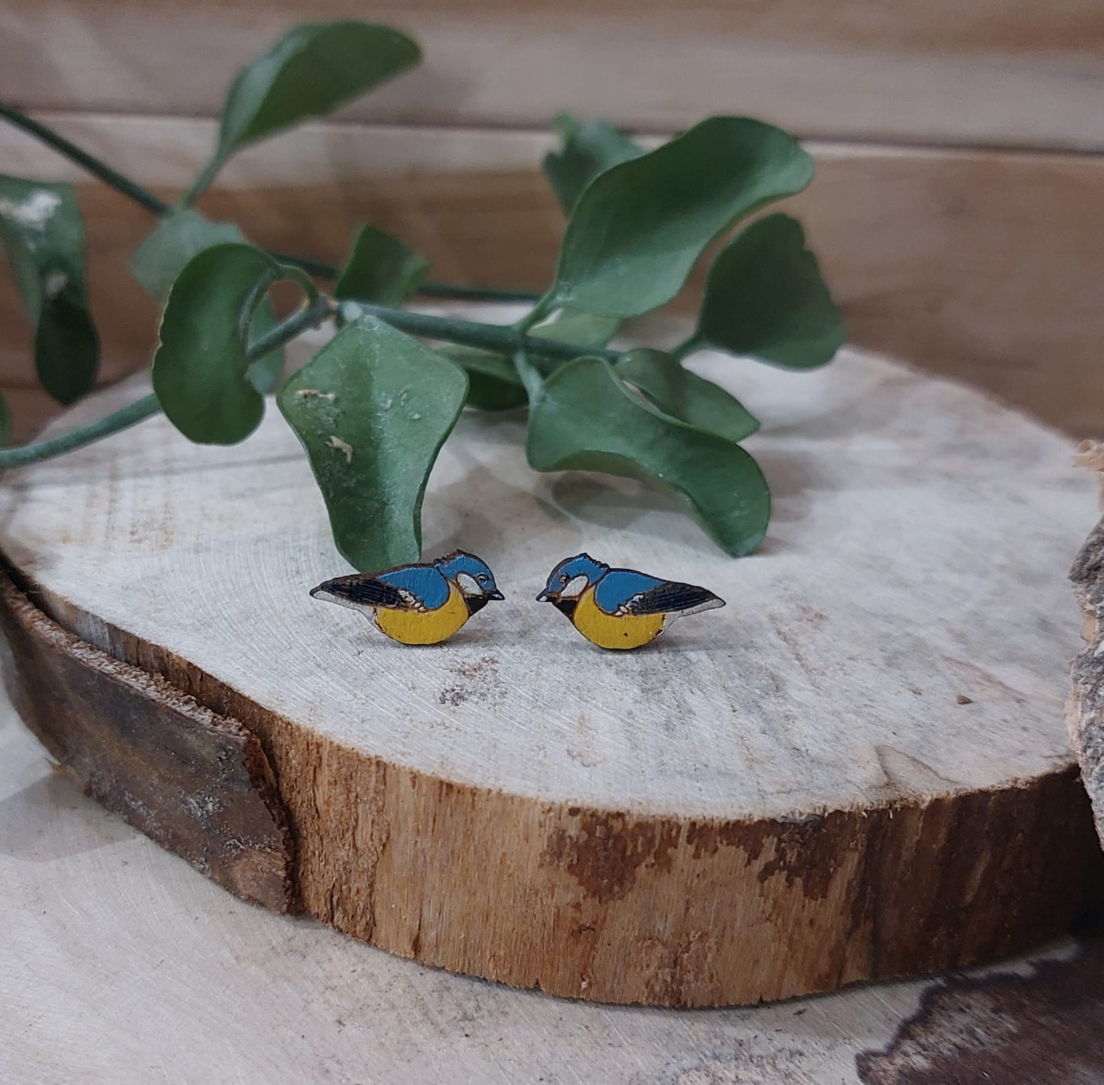 Na zdjęciu widać drewniane kolczyki przedstawiające sikorki.