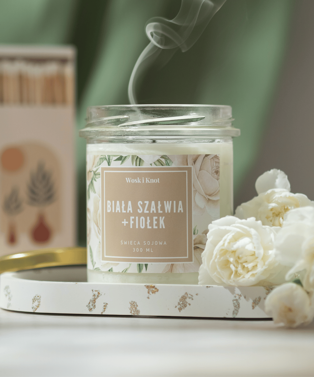 Na zdjęciu widać świecę o zapachu ,,Biała Szałwia+Fiołek'' w słoiczku.
